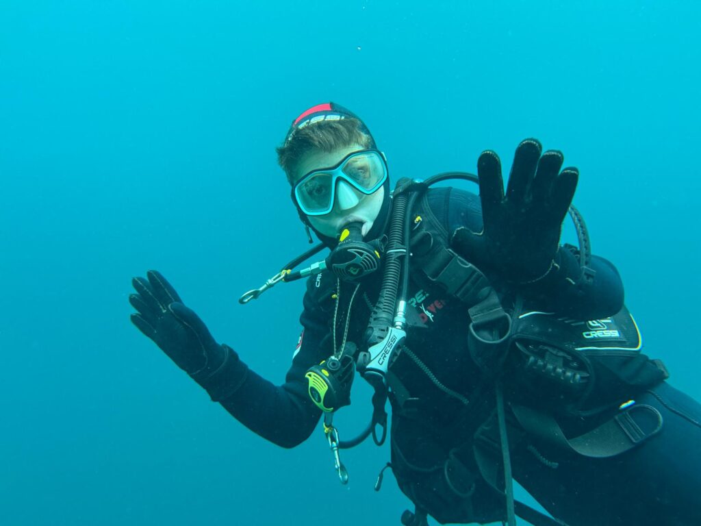 Bild eines fröhlichen jugendlichen Tauchers unter Wasser.